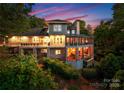Multi-story house featuring a wrap-around porch, screened-in space, and a view overlooking a green landscape at 10310 Wildlife Rd, Charlotte, NC 28278