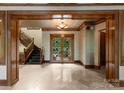 Grand foyer with detailed woodwork, stone floors, and ornate glass front doors at 10310 Wildlife Rd, Charlotte, NC 28278