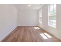 Bright, empty bedroom with wood-look flooring, white walls, and natural light from two windows at 222 Gilead Rd, Huntersville, NC 28078