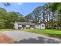 Ranch home with white brick exterior, gravel driveway and lush green lawn at 2178 Eastview Rd, Rock Hill, SC 29732