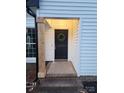 Inviting front entrance features a black door adorned with a wreath, complemented by wooden support beams at 513 Mary Charlotte Dr, Charlotte, NC 28262