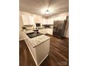 Modern kitchen featuring white cabinets, granite countertops, stainless steel appliances, and wood-look flooring at 513 Mary Charlotte Dr, Charlotte, NC 28262