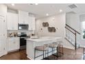 Stylish kitchen features a quartz island, stainless steel appliances, and modern backsplash at 1632 Village Grove Ln, Monroe, NC 28110