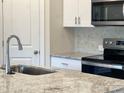 Close up of the sink with granite countertops, white cabinets, and stainless steel appliances at 1636 Village Grove Ln, Monroe, NC 28110