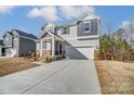 Two-story house with gray siding, stone accents, and a two-car garage at 12320 Riceland Way, Midland, NC 28107