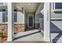 Front entry with stone and gray siding, columns and a covered porch at 12320 Riceland Way, Midland, NC 28107