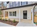 Charming front entrance with black door and white columns at 577 Westside Cir, China Grove, NC 28023