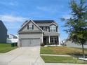 Charming two-story home with gray siding, a front porch, and a two-car garage at 1109 Creedmore Ct, Charlotte, NC 28215