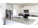 Modern kitchen with white cabinets, granite countertops, and stainless steel appliances at 1109 Creedmore Ct, Charlotte, NC 28215