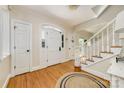Inviting foyer with hardwood floors, a staircase with white railings, and an arched doorway with glass detailing at 5300 Green Rea Rd, Charlotte, NC 28226