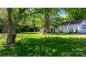 Large grassy backyard featuring mature trees and a detached garage at 112 S 2Nd Ave, Maiden, NC 28650