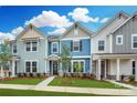Three-unit townhome building, featuring light blue, gray, and white exteriors at 10507 Boudreaux St, Huntersville, NC 28078