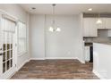 Bright dining area with wood floors, modern lighting, and access to the outdoors at 7215 Gallery Pointe Ln, Charlotte, NC 28269