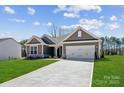 Charming single-story home with a manicured lawn and a two-car garage, showcasing modern curb appeal at 120 Brooke Forest Ct, Mooresville, NC 28115