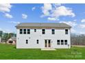 Bright white two-story home featuring sliding glass patio doors and a spacious backyard at 126 Brooke Forest Ct, Mooresville, NC 28115