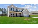 Attractive two-story home with a covered porch, attached garage, and lush green lawn at 126 Brooke Forest Ct, Mooresville, NC 28115