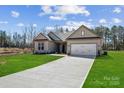 Beautifully designed single-story home with a lush green lawn and an attached garage at 132 Brooke Forest Ct, Mooresville, NC 28115