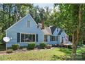 Blue house with green shrubs and a deck, nestled among trees at 200 Cleveland Ave, Shelby, NC 28150