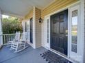 Front porch with rocking chairs and a black front door at 615 Real Quiet Ct, York, SC 29745