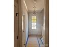 Bright entryway with white door, chandelier, and staircase at 207 Davidson Gateway Dr, Davidson, NC 28036