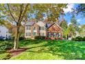 Charming two-story home with a manicured lawn, brick and vinyl siding, and complemented by lush, mature trees at 138 Huntly Ln, Mooresville, NC 28115