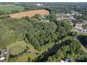 Aerial view of a wooded lot with a curved driveway, near other buildings at 1116 Medlin Rd, Monroe, NC 28112