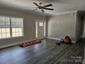 Bright living room showcasing dark laminate flooring, a modern ceiling fan, and a window view of the outdoors at 2054 Cane Mill Rd, Lancaster, SC 29720