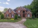 Lovely two-story brick home with lush landscaping, black shutters, and a curved driveway at 2840 Wheat Field Ct, Lincolnton, NC 28092