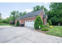 Spacious two-car garage with a brick exterior, surrounded by lush landscaping and mature trees at 2840 Wheat Field Ct, Lincolnton, NC 28092