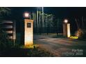 Nighttime shot of lighted brick entrance columns with address plaque, and automatic driveway gate beyond at 1046 Sutton Spring Rd, York, SC 29745