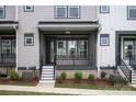 Charming gray townhouse featuring a covered front entrance with black rails and well-maintained landscaping at 429 Nathaniel Way # Brx0032, Charlotte, NC 28213