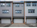 Two-story townhome showcasing a convenient attached garage and classic gray siding at 433 Nathaniel Way # Brx0033, Charlotte, NC 28213