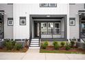 The townhome has a covered porch with a neutral color scheme and simple landscaping at 437 Nathaniel Way # Brx0034, Charlotte, NC 28213