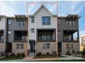 Detailed view of townhome exterior showing a white vertical siding, brick facade, and dark accents at 436 Nathaniel Way # Brx0042, Charlotte, NC 28213