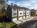 Back of townhome featuring a two-car garage, driveway, and neatly landscaped yard space at 436 Nathaniel Way # Brx0042, Charlotte, NC 28213