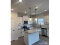 Modern kitchen with island, stainless steel appliances, and white cabinetry at 608 Lispenard Ct, Mount Holly, NC 28120