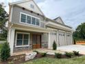 View of front exterior with stacked stone, wood doors, and 3-car garage at 139 Poplar Grove Rd, Mooresville, NC 28117