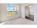 Bright bedroom with large windows offering scenic views, plush carpeting, and access to an adjacent room at 1034 Heath Helms Rd, Monroe, NC 28110