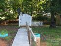 Backyard with a white shed, surrounded by greenery, offering a peaceful and private outdoor retreat at 112 S Cardinal Dr, New London, NC 28127