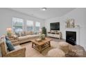 Living room features fireplace, light colored couch, and wooden coffee table at 129 Eden Ave, Mooresville, NC 28115