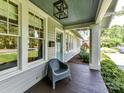 Inviting front porch with stylish chair, decorative light fixture, and view of the yard at 2110 E 5Th St, Charlotte, NC 28204