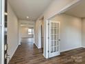 Open foyer with wood flooring, neutral paint, and view to rooms at end of hall at 8021 Franklin Trail St, Mint Hill, NC 28227