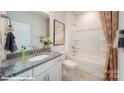 Cozy bathroom featuring granite countertops, a tub, a shower, and decorative striped curtains at 133 Sari St, Troutman, NC 28166