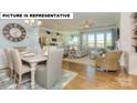 Open-concept living space with dining area, kitchen, and living room featuring hardwood floors at 145 Sari St, Troutman, NC 28166