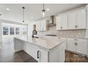 Modern kitchen features white cabinets, stainless steel appliances, an island, and hardwood floors at 2140 Indigo Branch Rd, Indian Land, SC 29707