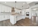 Bright kitchen with white cabinets, a large island, stainless steel appliances, and hardwood floors at 2140 Indigo Branch Rd, Indian Land, SC 29707
