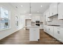 Bright, modern kitchen with white cabinets, stainless appliances, and pendant lighting at 3112 Beacon Heights Rd, Indian Land, SC 29707