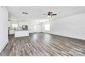 Open-concept living space with wood-look floors, connecting the living room, kitchen, and dining area for seamless living at 4206 Old Monroe Marshville Rd, Wingate, NC 28174