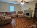 Cozy living room features hardwood floors, a brick fireplace, and comfortable seating, perfect for relaxation at 113 Fairview St, Clover, SC 29710