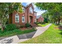 Charming red brick home with arched windows, manicured landscaping, and a inviting walkway to the front door at 102 Sleaford Ct, Dallas, NC 28034